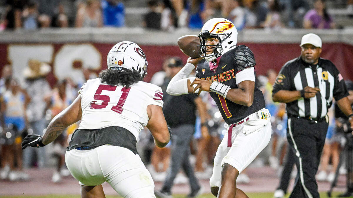 Clovis West quarterback Jamar (JJ) Howard, right, looks to throw while getting pressure from an Edison defender in the first half of their game at Veterans Memorial Stadium in Clovis on Friday, Sept. 5, 2025.